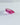 Pavilion profile of an elongated pink lab-grown sapphire on a pale textured surface.