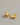 A close-up of a pair of minimalist, high-gloss oval bean stud earrings plated in 18K real gold, featuring a hollow back design and 925 sterling silver posts, resting on a smooth grey background.-3