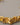 A close-up of a chunky, premium open-cuff bracelet featuring an irregular molten gold and crushed foil texture, made of real gold-plated brass, resting elegantly on a smooth grey background.-2