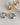 A close-up of a pair of thick, highly polished 18K gold-plated huggie hoop earrings featuring a smooth tapered design and a secure hinged snap closure, isolated on a white background.-4