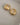 A close-up of a pair of thick, highly polished 18K gold-plated huggie hoop earrings featuring a smooth tapered design and a secure hinged snap closure, isolated on a white background.-7