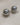 A close-up of two pairs of high-gloss dome stud earrings in gold and silver finishes, showing the smooth half-sphere front and the hollow-back construction with stud posts, resting on a textured cream fabric-8